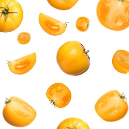 Fresh ripe yellow tomatoes falling on white background