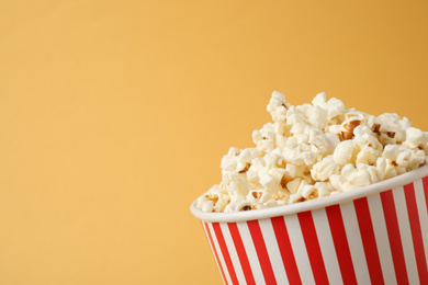 Delicious popcorn on yellow background, closeup. Space for text