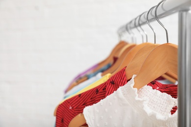 Wardrobe rack with stylish clothes on white background, closeup. Space for text