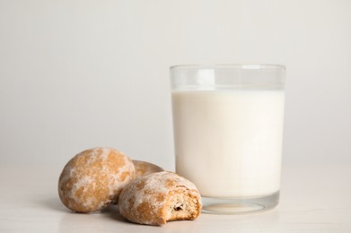 Photo of Tasty homemade gingerbread cookies and glass of milk on white table