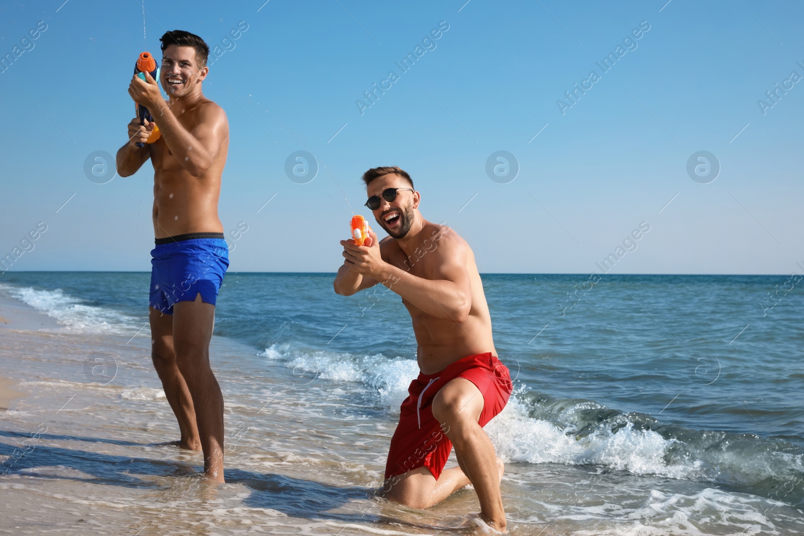 Photo of Friends with water guns having fun on beach