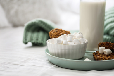 Cookies, marshmallows and milk on bed. Delicious morning meal