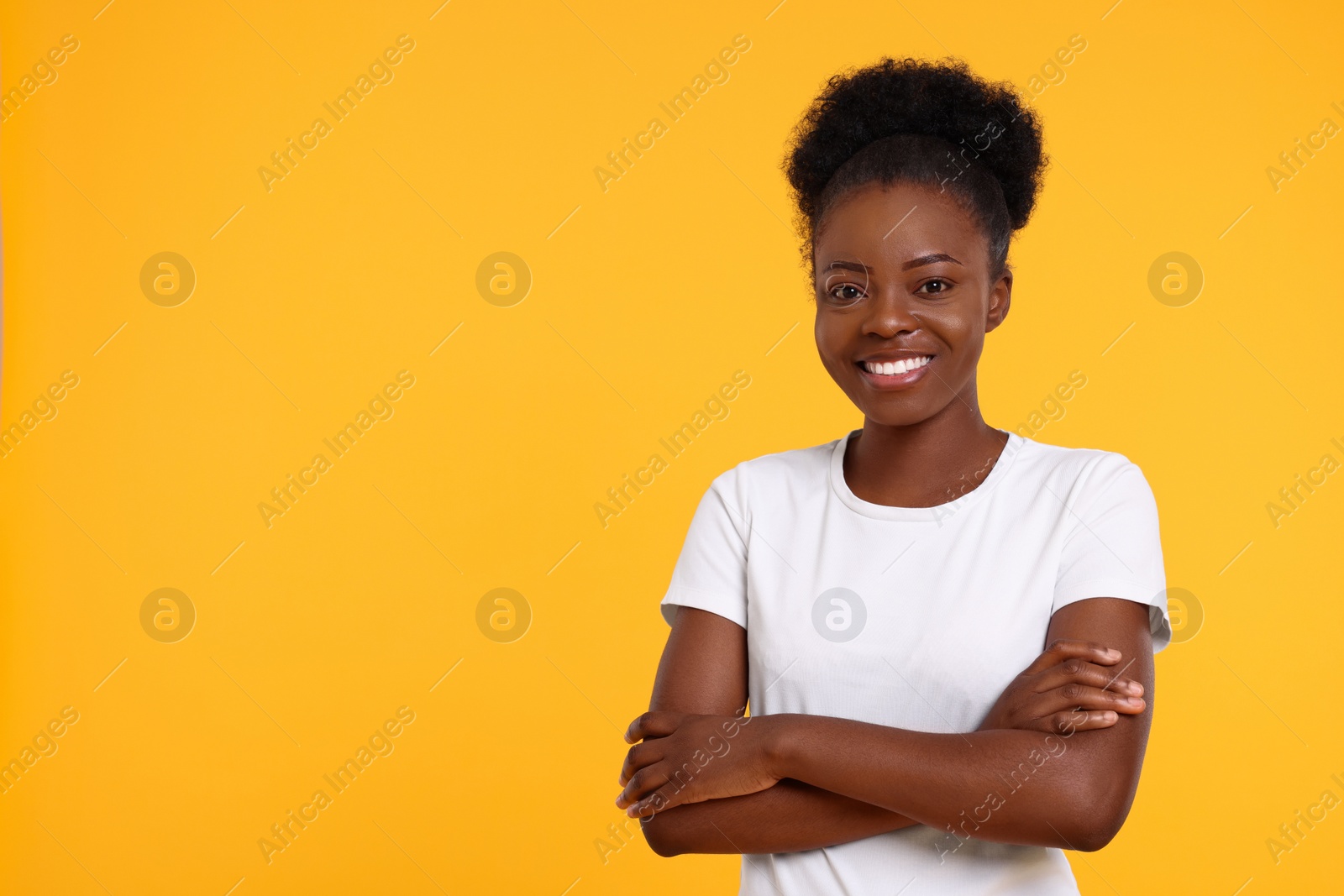 Photo of Portrait of happy young woman on orange background. Space for text