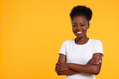 Portrait of happy young woman on orange background. Space for text