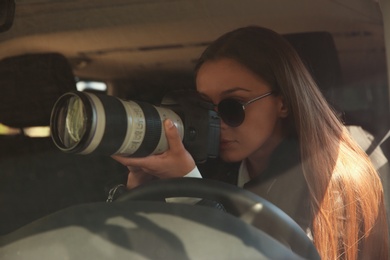 Private detective with camera spying from car