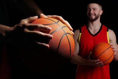 Image of Basketball players with leather balls on black background, collage