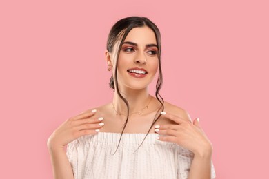 Photo of Beautiful woman with elegant jewelry on pink background