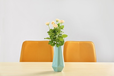 Photo of Vase with blooming flowers on table indoors