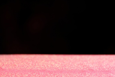 Photo of Glitter on table against dark background. Bokeh effect