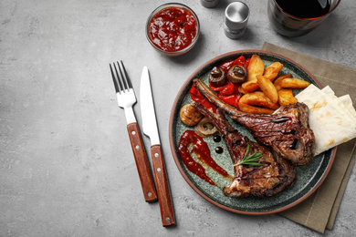 Delicious grilled ribs served on light grey table, flat lay