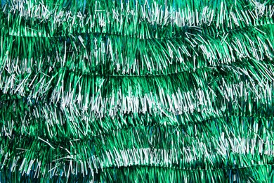 Photo of Bright green tinsel as background. Festive decoration
