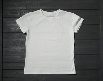 Stylish white T-shirt on gray wooden table, top view