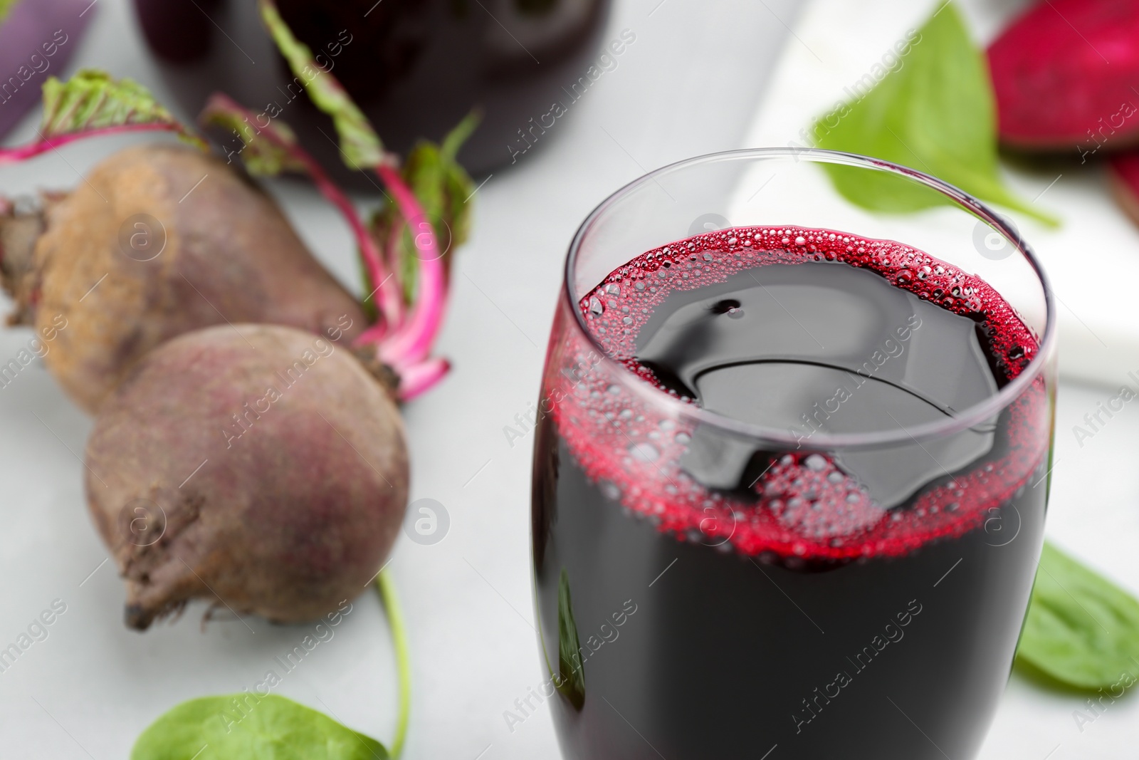 Photo of Freshly made beet juice in glass on table, closeup