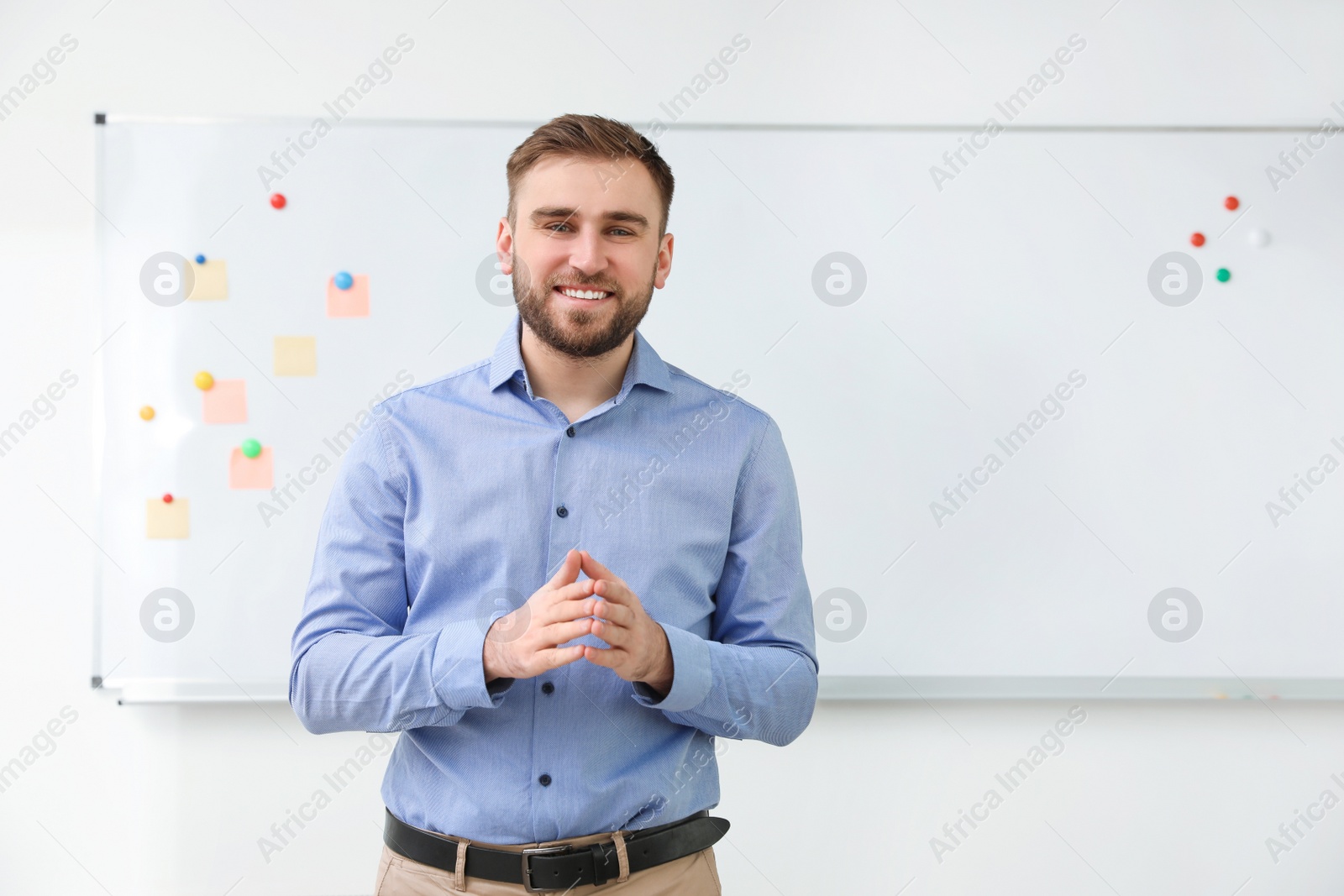 Photo of Portrait of young teacher near whiteboard in classroom