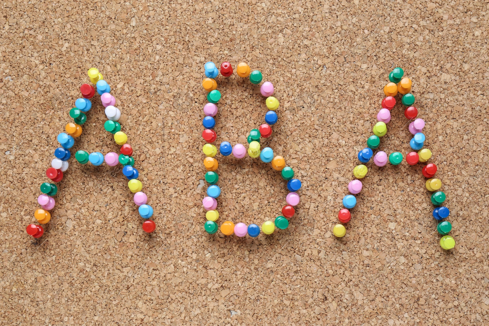 Photo of Applied behavior analysis concept. Corkboard with abbreviation ABA made of colorful pins