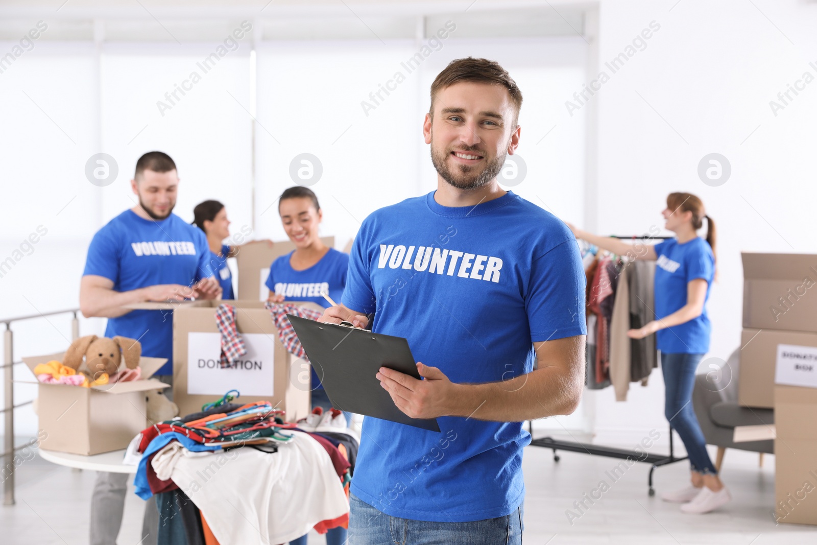 Photo of Male volunteer with clipboard listing donations indoors