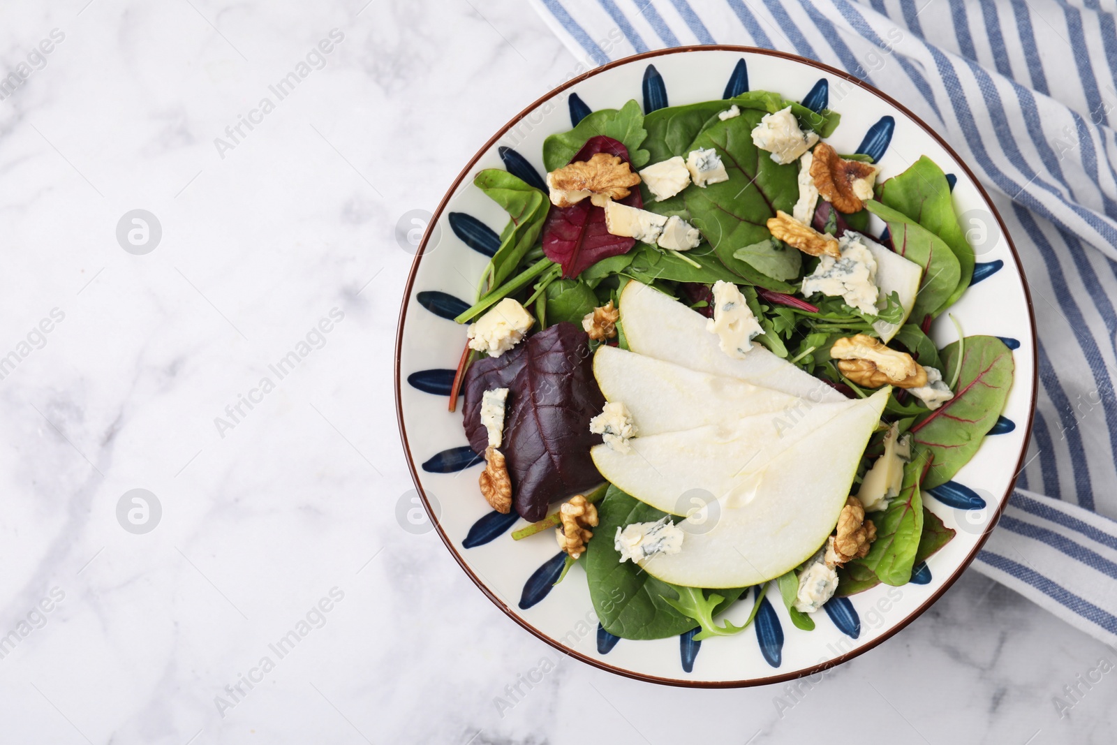 Photo of Delicious pear salad in bowl on white marble table, top view. Space for text