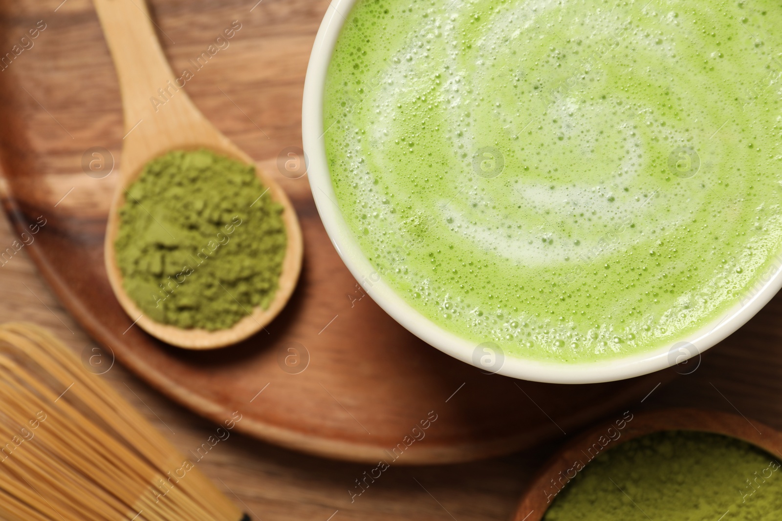 Photo of Cup of fresh matcha latte and powder on table, flat lay