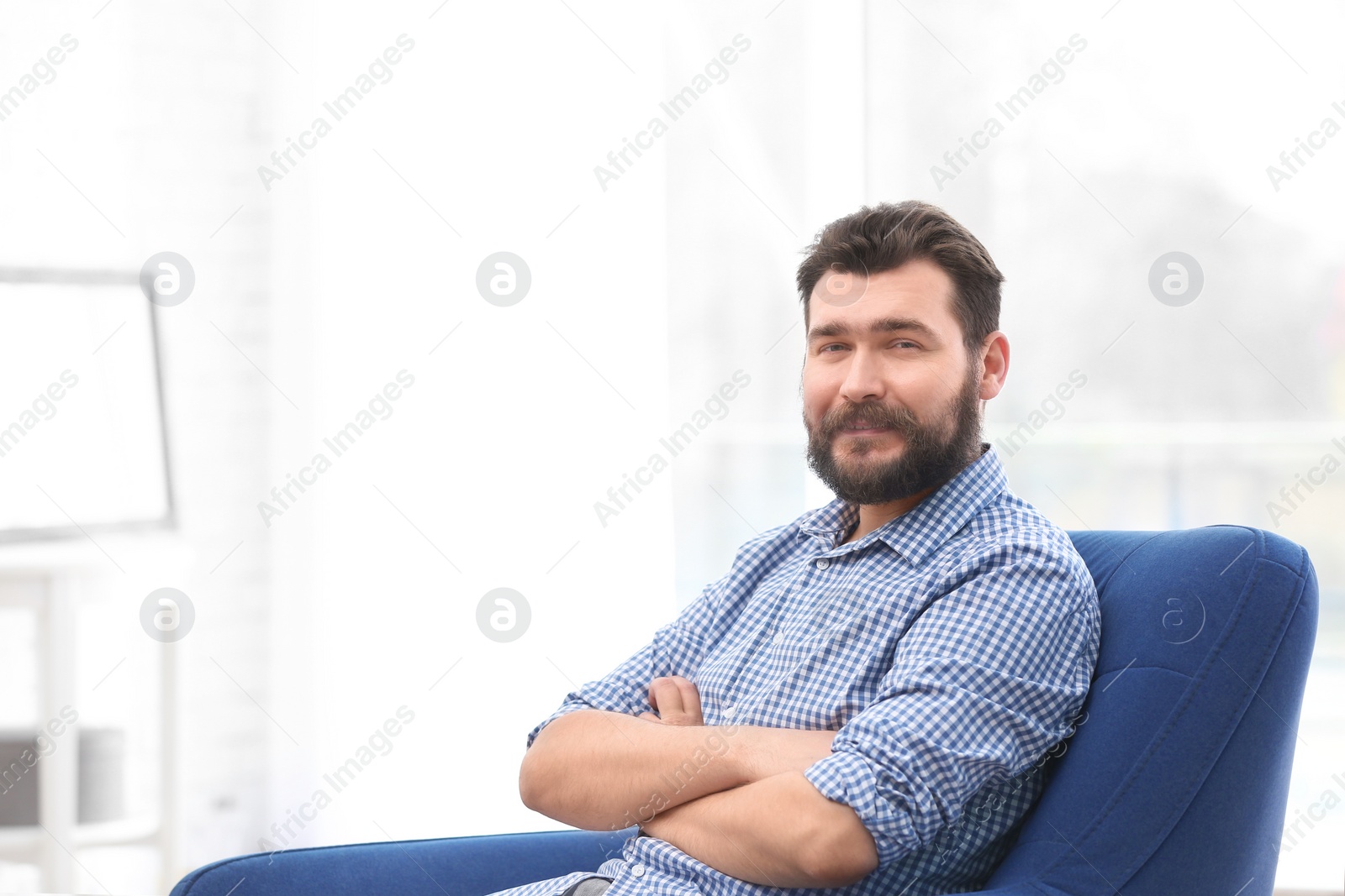 Photo of Portrait of confident mature man in armchair