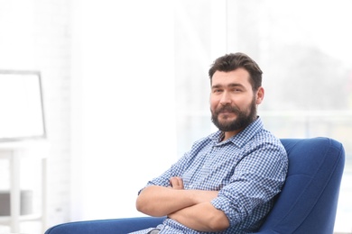 Portrait of confident mature man in armchair