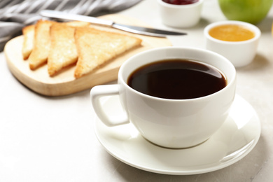 Photo of Fresh hot coffee on light grey marble table. Tasty breakfast