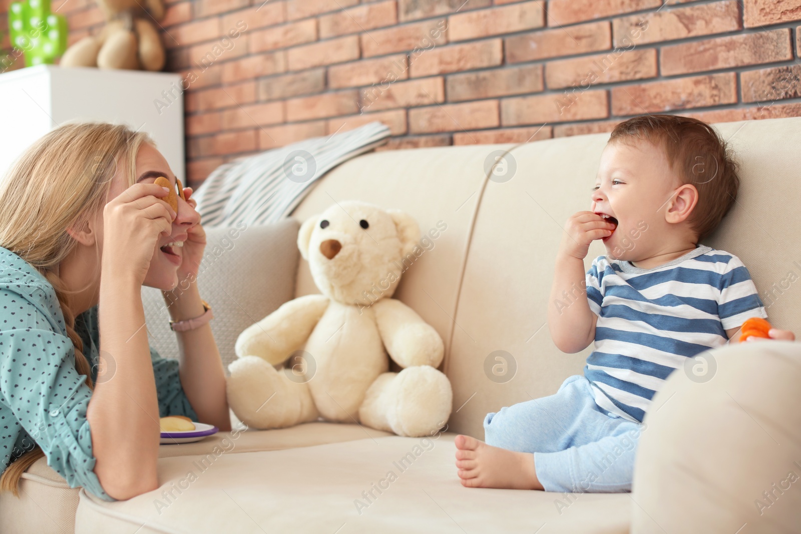 Photo of Woman playing with child while feeding him at home. Healthy baby food