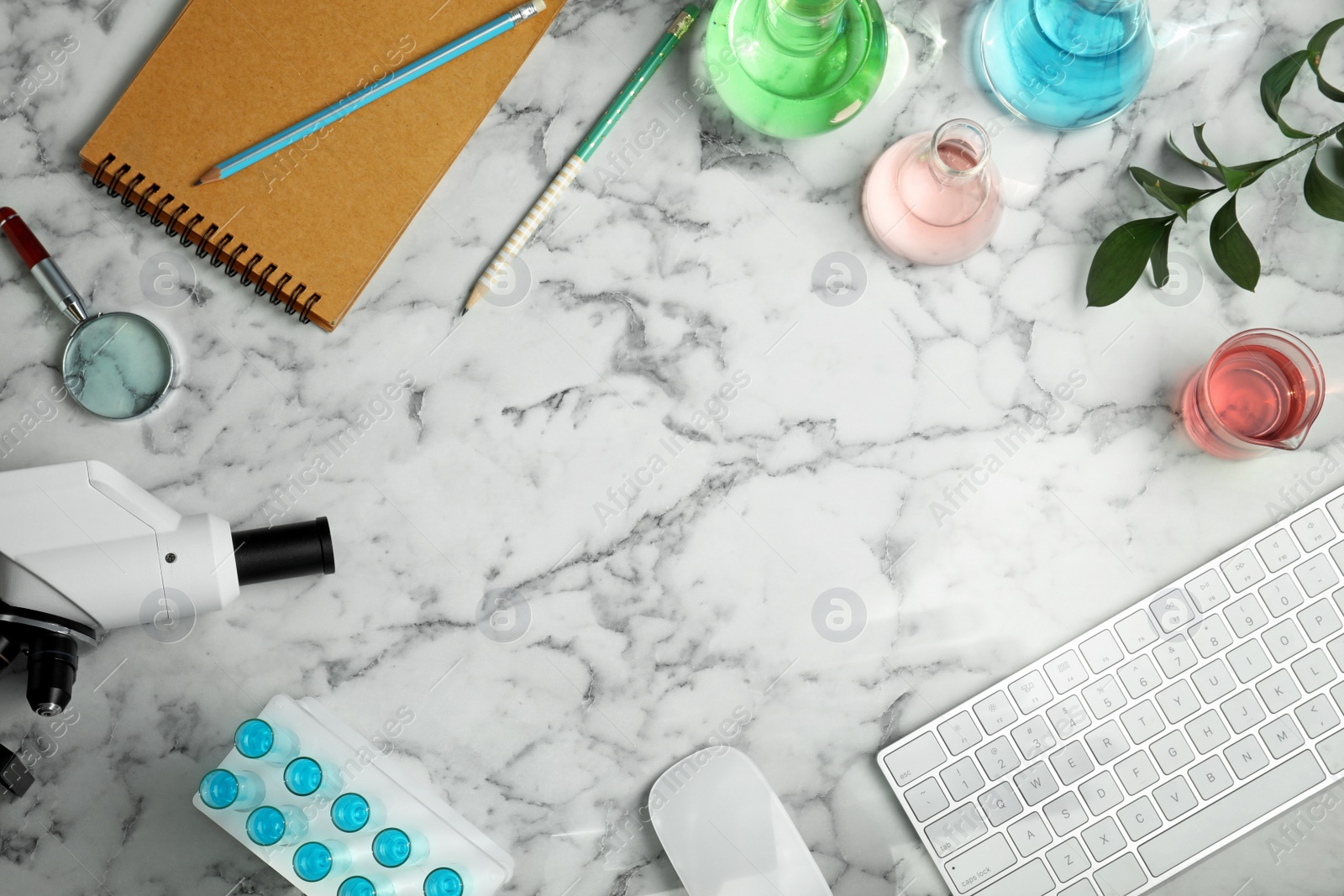 Photo of Flat lay composition with laboratory glassware, microscope and stationery on marble background, space for text. Chemistry concept