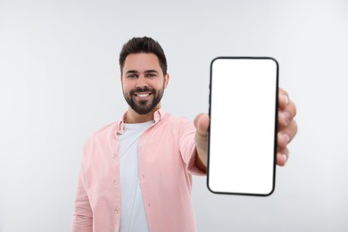 Young man showing smartphone in hand on white background