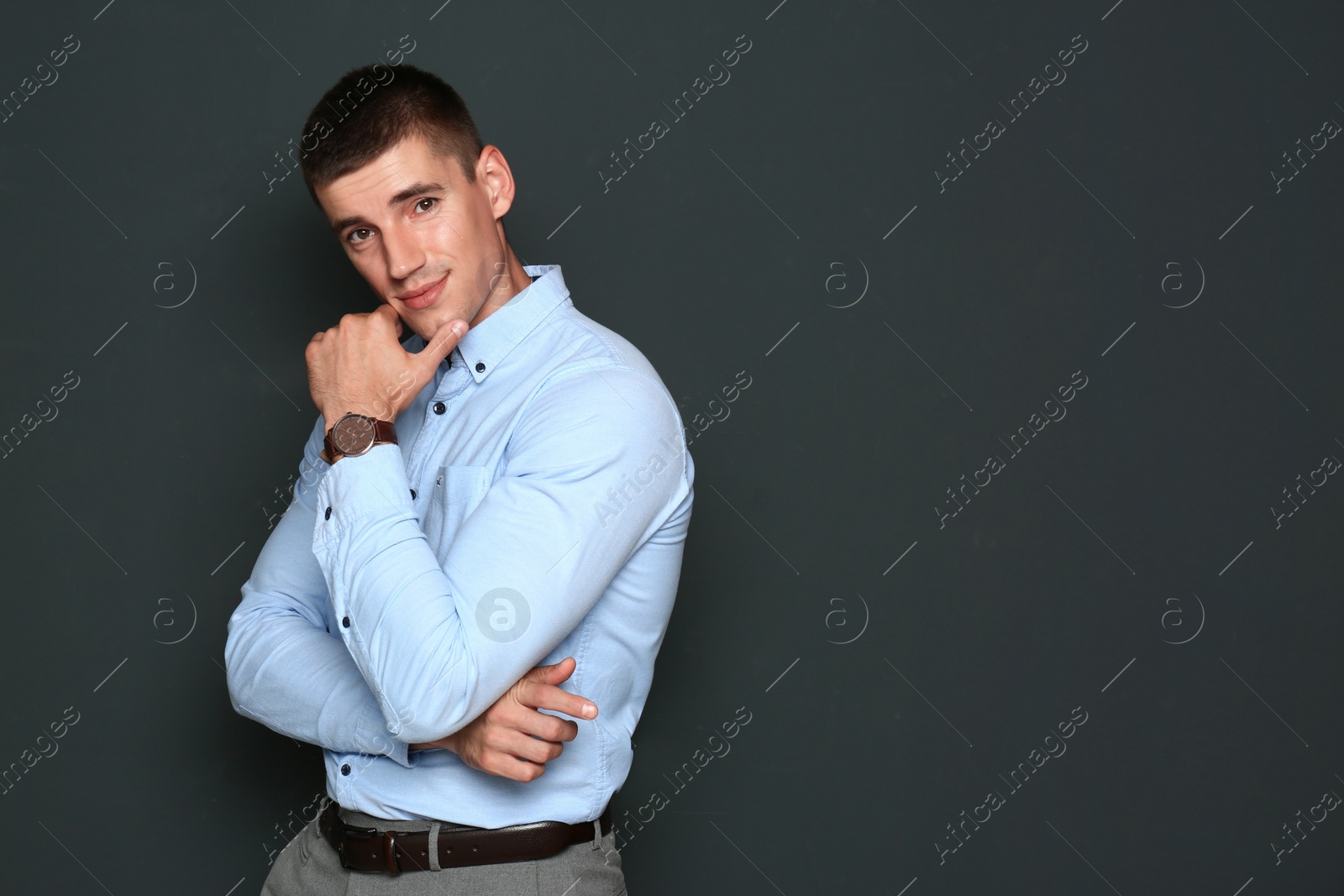 Photo of Portrait of handsome young man on dark background. Space for text