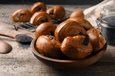 Photo of Freshly baked poppy seed buns in bowl on table