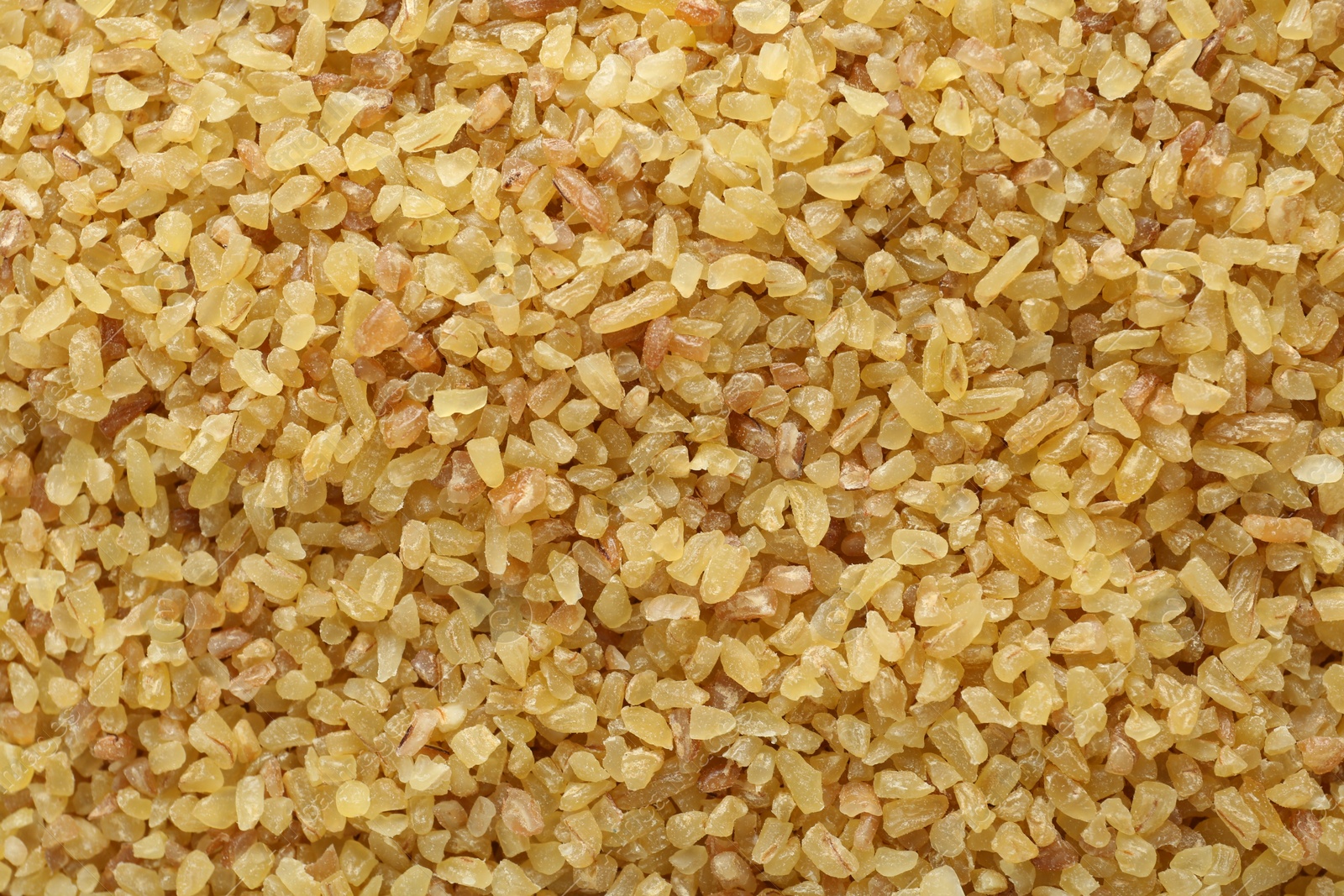 Photo of Pile of uncooked bulgur as background, top view