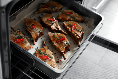 Delicious roasted ribs on baking tray in oven