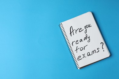 Photo of Notebook with phrase Are You Ready For Exams on turquoise background, top view. Space for text