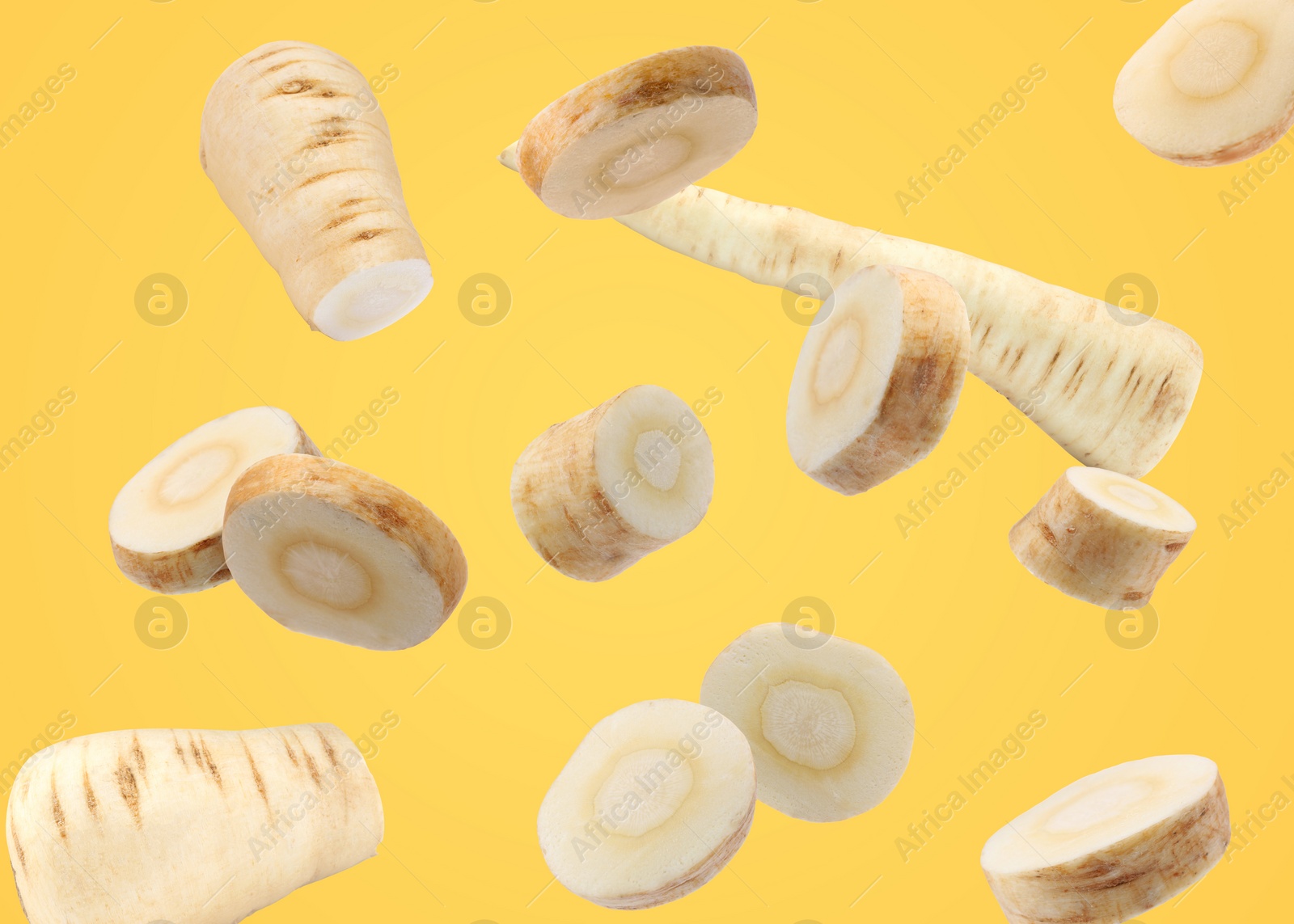 Image of Pieces of parsnip root falling on pale orange background
