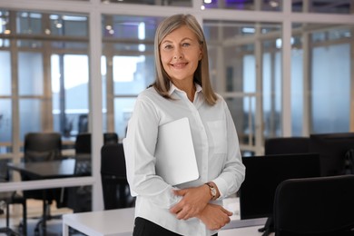Photo of Smiling woman with laptop in office. Lawyer, businesswoman, accountant or manager