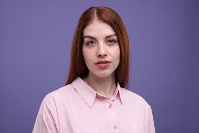 Portrait of beautiful woman with freckles on purple background