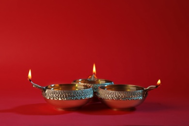 Photo of Diwali diyas or clay lamps on color background