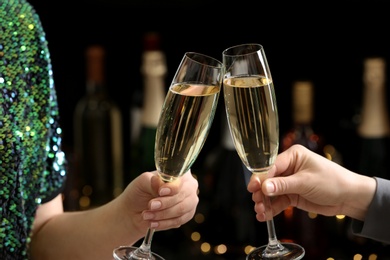 Photo of People clinking glasses of champagne on blurred background, closeup