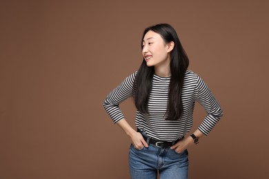 Portrait of smiling woman on brown background. Space for text