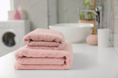 Photo of Stack of clean towels on bathroom countertop. Space for text