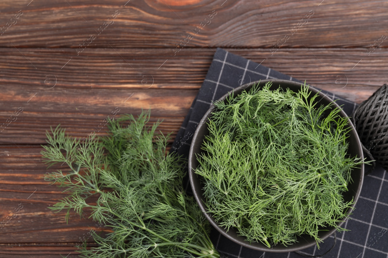 Photo of Bowl of fresh dill on wooden table, flat lay. Space for text