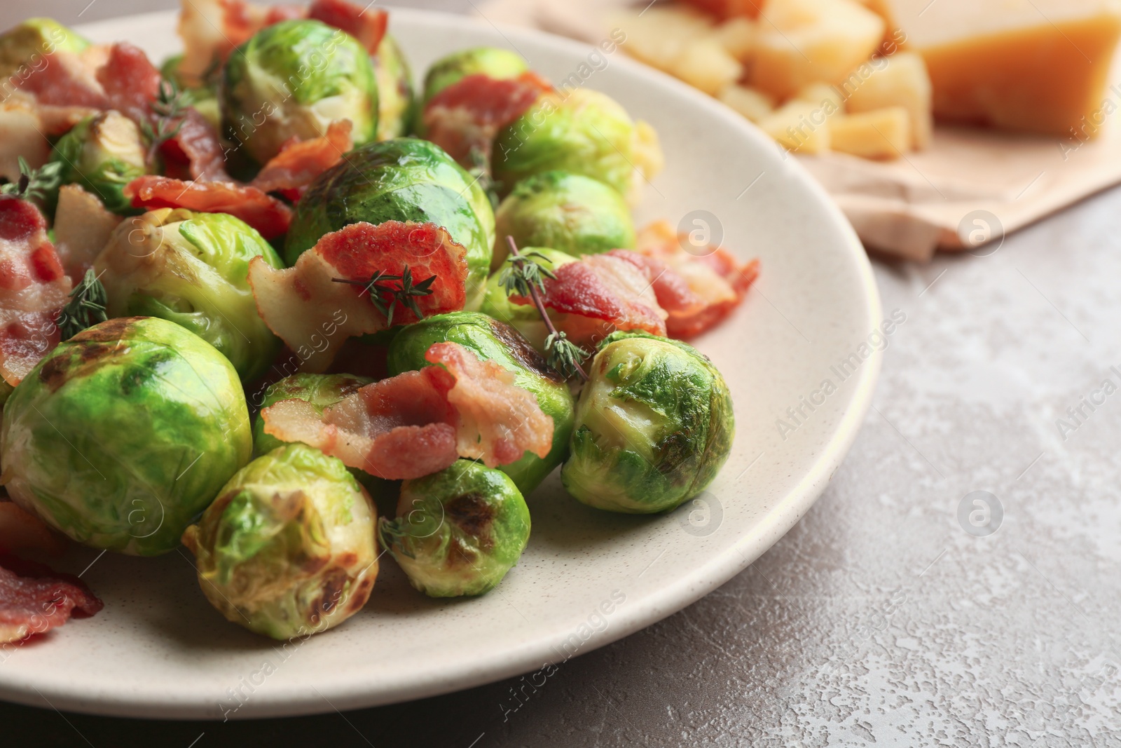 Photo of Delicious Brussels sprouts with bacon on table, closeup