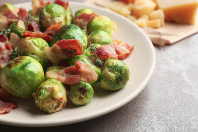 Delicious Brussels sprouts with bacon on table, closeup