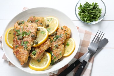 Photo of Delicious chicken piccata served on white wooden table