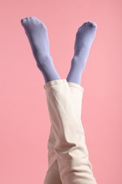 Woman in stylish purple socks and pants on pink background, closeup