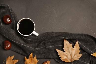 Flat lay composition with hot cozy drink and autumn leaves on dark background. Space for text