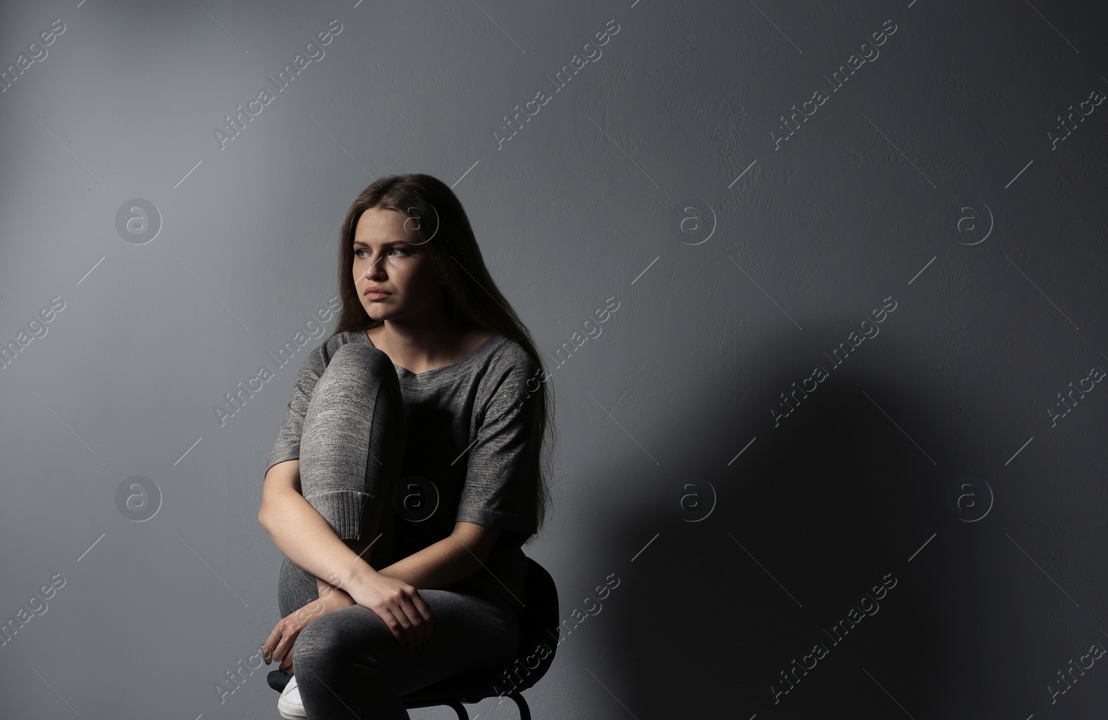 Photo of Depressed young woman on gray background