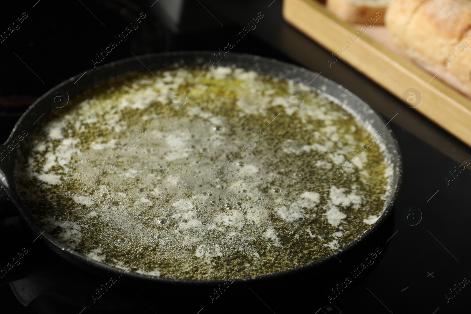 Photo of Melted butter in frying pan on table, closeup