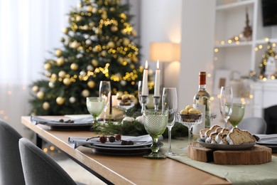 Christmas table setting with festive decor and dishware in room