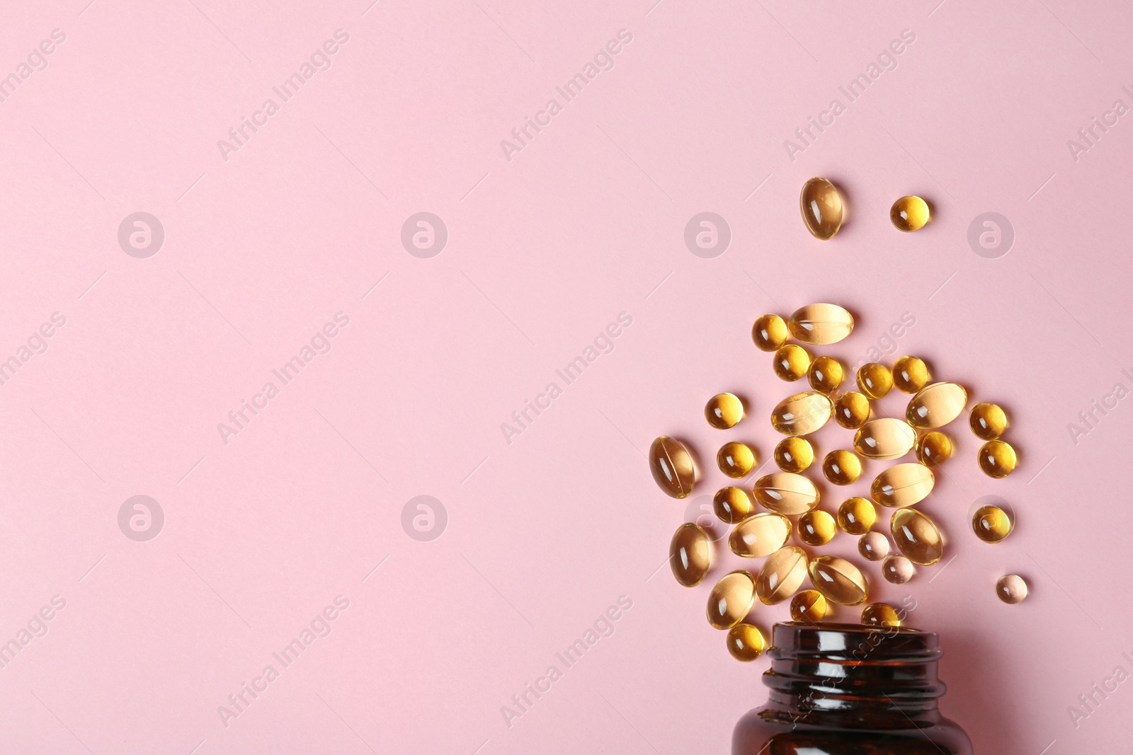 Photo of Bottle with cod liver oil capsules on color background, flat lay. Space for text